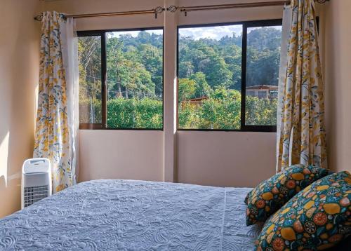 a bedroom with a bed and a large window at Casa Farolito in Hone Creek