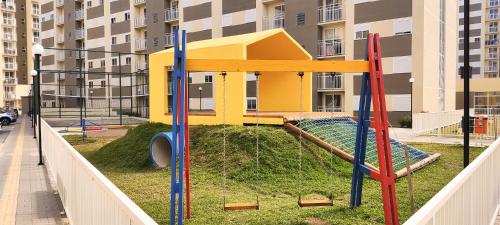 um parque infantil em frente a um edifício de apartamentos em APT° Aconchegante Acqua Park em Pelotas