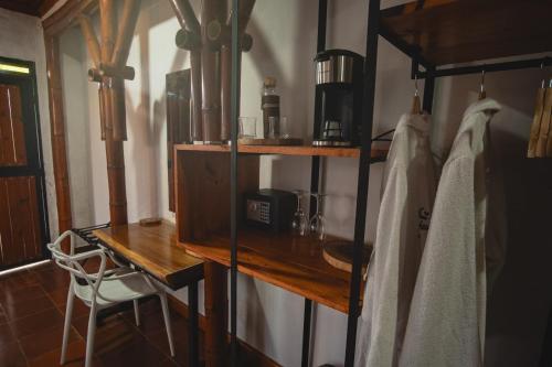 Camera con mensola in legno e scrivania con macchinetta del caffè. di Ecoresort Colombo Holandes a Cali