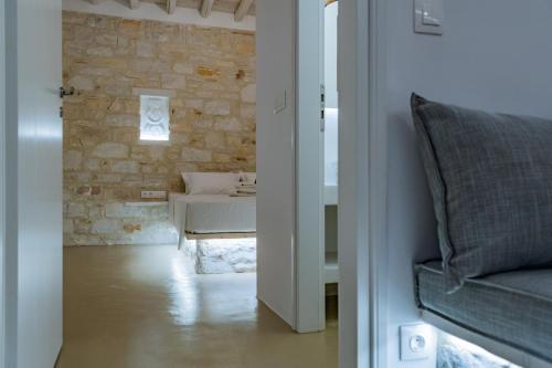a living room with a couch and a stone wall at Aegean Feelings in Piso Livadi