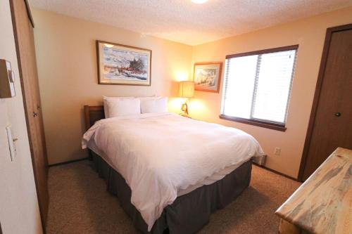 a bedroom with a large white bed with a window at Trapper 8 in West Yellowstone