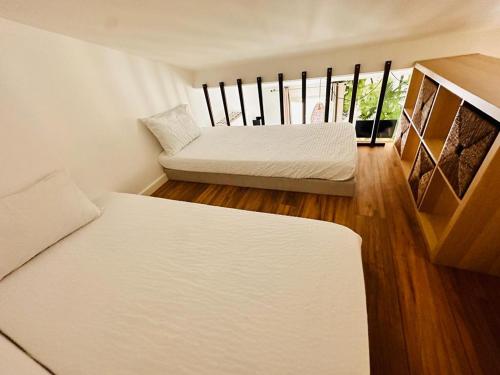 - 2 lits dans une petite chambre dotée de parquet dans l'établissement Les Appartements de Nana 12 - Studio hypercentre, Rue Meynadier, Palais & Plage, clim, wifi, à Cannes