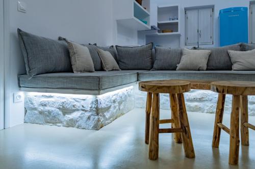 a living room with two wooden stools in front of a couch at Aegean Feelings in Piso Livadi