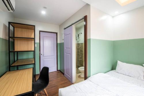 een slaapkamer met een bed en een bureau en een badkamer bij St. Marvin Studio Makati M308 in Manilla