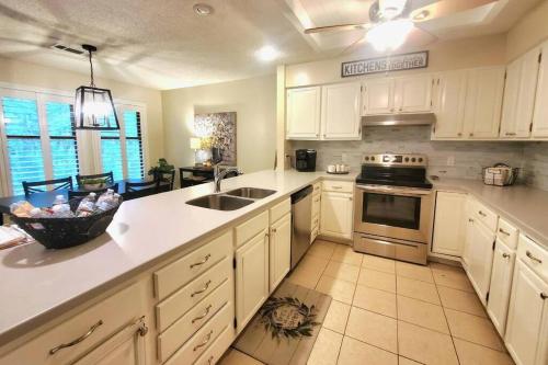 a kitchen with white cabinets and a sink and an oven at Hidden Gem 3bd/2bth 1levl in Hot Springs Village
