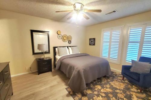 a bedroom with a bed and a ceiling fan and a chair at Hidden Gem 3bd/2bth 1levl in Hot Springs Village