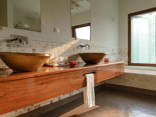 a bathroom with two wooden sinks and a tub at Montebelo Gorongosa Lodge & Safari in Chitengo