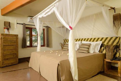 a bedroom with a bed with a canopy at Montebelo Gorongosa Lodge & Safari in Chitengo