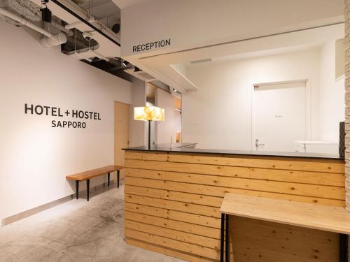 a room with a wooden counter and a bench at Hotel Plus Hostel SAPPORO in Sapporo