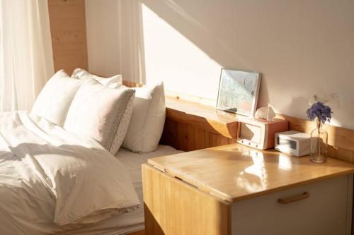 a bedroom with a bed and a desk with a window at Le Village Aewol building A in Jeju