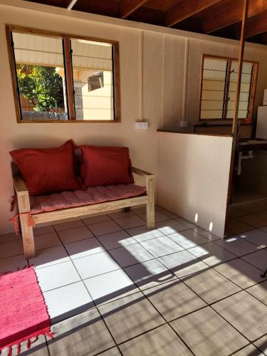 un soggiorno con divano su un pavimento piastrellato di Le chalet Scarlet a Teahupoo