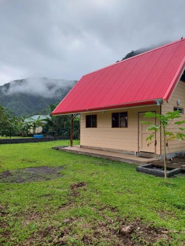 a red roofed house with a red roof at Le chalet Scarlet in Teahupoo