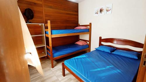 een slaapkamer met 2 stapelbedden en een blauw bed bij Casa Colonial em Guaratuba, próximo a praia in Guaratuba