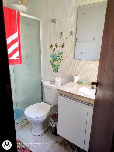 a bathroom with a toilet and a sink and a mirror at Flat 3 quartos Gravatá Winterville in Gravatá