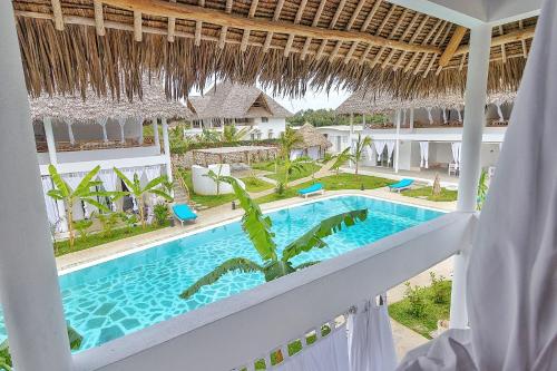 een uitzicht vanaf het balkon van een resort met een zwembad bij Cacuki Boutique House in Watamu