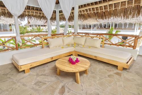 Sala de estar con 2 camas y mesa en Cacuki Boutique House en Watamu