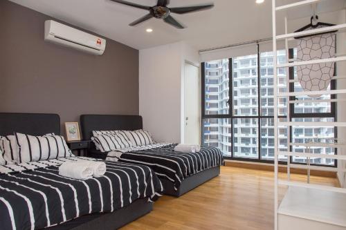 two beds in a room with a large window at KL Gateway Bangsar By Sleepy Bear in Kuala Lumpur