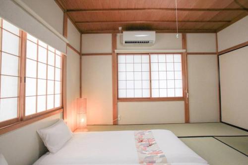 a room with a bed and two windows at 飛騨高山　一の心 in Takayama