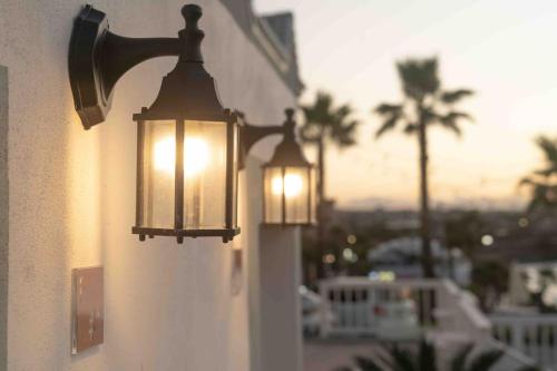 two lights on the side of a wall with a view at Le Village Aewol F in Jeju