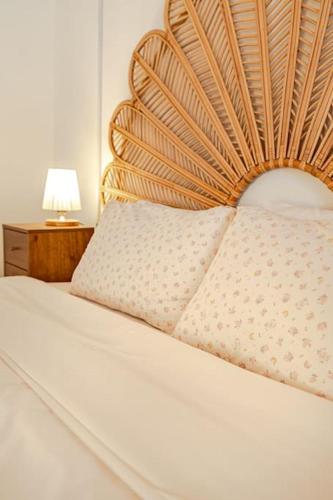 a bed with a wooden headboard and a lamp on a table at Le Village Aewol F in Jeju