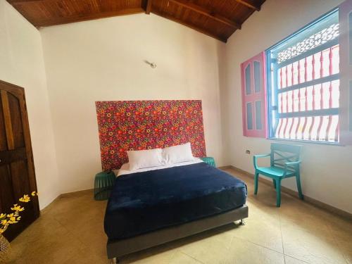 1 dormitorio con 1 cama y una pared colorida en Aloja-T en Casa amoblada en Jericó, en Jericó