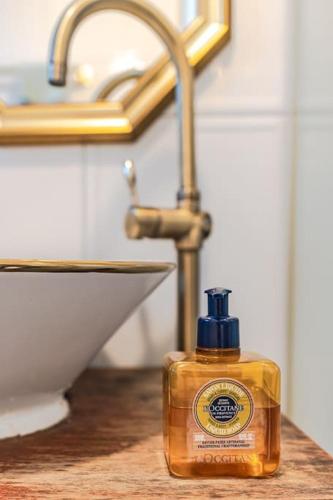 a bottle of soap sitting on a counter next to a sink at Le Village Aewol F in Jeju