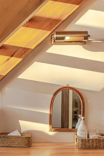 a bathroom with a mirror and a sink at Le Village Aewol F in Jeju