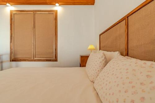a bedroom with a bed with a wooden headboard and a window at Le Village Aewol F in Jeju