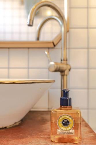 a bottle of soap sitting on a counter next to a sink at Le Village Aewol F in Jeju