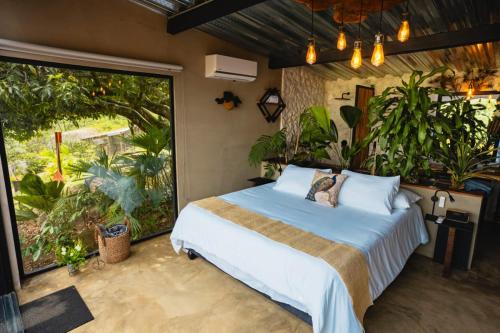 een slaapkamer met een bed en een groot raam bij Ecoresort Colombo Holandes in Cali