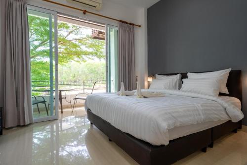 a bedroom with a large bed and a balcony at 1Br Poolside Apartment, Long Beach, Lanta Sport Resort 109 in Ko Lanta