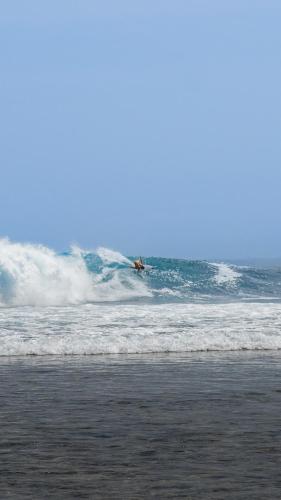 a person riding a wave on a surfboard in the ocean at Sumatra Surf Resort in Biha