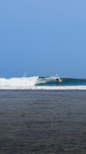 a person riding a wave in the ocean at Sumatra Surf Resort in Biha