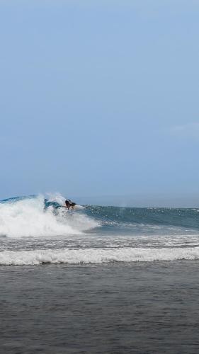 a person riding a wave on a surfboard in the ocean at Sumatra Surf Resort in Biha