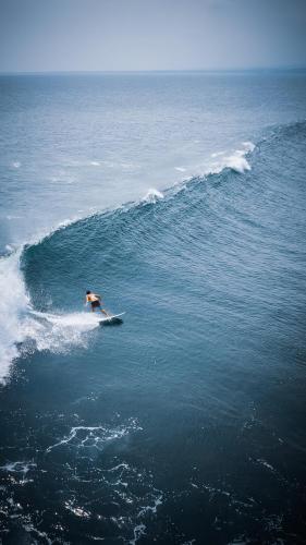 a person riding a wave on a surfboard in the ocean at Sumatra Surf Resort in Biha