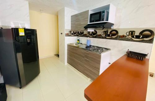 a kitchen with a black refrigerator and a microwave at Apartamento Madrid cund in Madrid