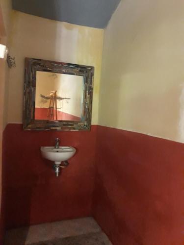 a bathroom with a sink and a mirror at Big Daddy´s Surfcamp in Pasanggaran