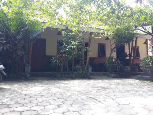 a house with a courtyard in front of it at Big Daddy´s Surfcamp in Pasanggaran