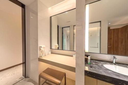 uma casa de banho com um lavatório e um espelho grande em Carnelian Tower - Balcony & Sunset View 4204 em Gelang Patah