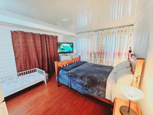 Un dormitorio con una cama y un televisor de pantalla plana. en Kaban Power 7, en Doonside