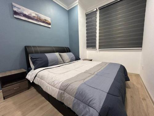 a bedroom with a bed and a window with blinds at Spacious Home @ Kuching City Ctr in Kuching