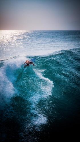 a man riding a wave in the ocean at Sumatra Surf Resort in Biha