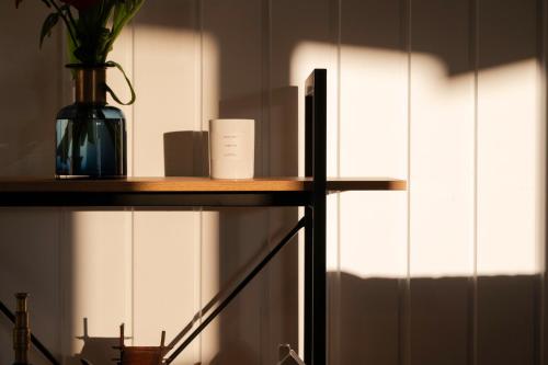 a room with a shelf with a vase on it at Pukehina Estuary Sunset Views Holiday Home in Pukehina