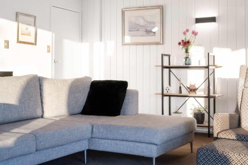 a living room with a blue couch and a chair at Pukehina Estuary Sunset Views Holiday Home in Pukehina