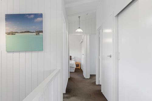 a hallway with a room with a bed and a painting at Pukehina Estuary Sunset Views Holiday Home in Pukehina