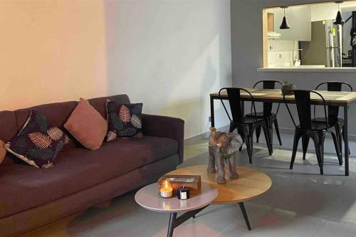 - un salon avec un canapé et une table avec une statue de chat dans l'établissement Cómodo apto, excelente ubicación Sabaneta, à Sabaneta