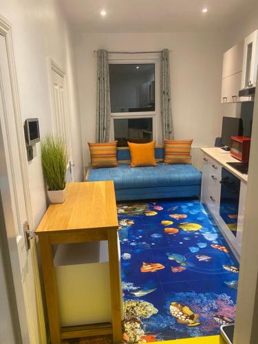 salon z niebieską podłogą z dywanem rybnym w obiekcie Ziggla Luxury Apartments w Londynie