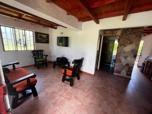 sala de estar con sillas y chimenea de piedra en Cabaña Chalet La Lomita, en San Gil