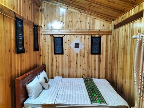 薩帕的住宿－Sapa Shalom Homestay，卧室配有木墙内的一张床