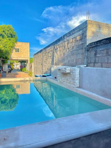 a pool of water next to a brick building at Casa Lol-cab Hostal in Valladolid